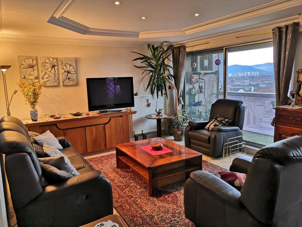 un salon avec deux canapés et une télévision dans l'établissement Bel appartement avec vue splendide sur toute la ville de Colmar - Parking gratuit, à Colmar