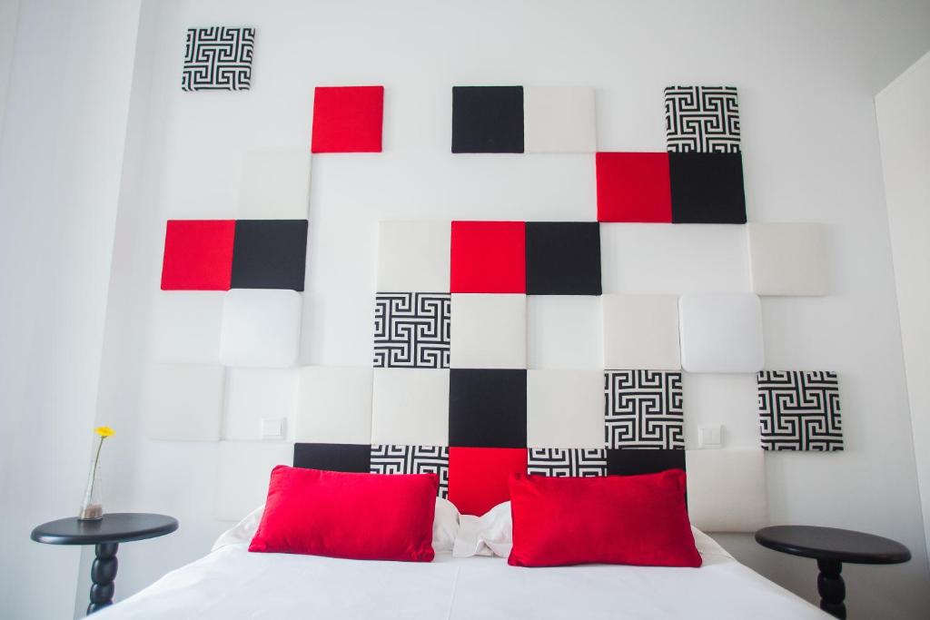 トマールにあるトーマー ストーリー ゲストハウスのベッドルーム(白いベッド、赤い枕付)