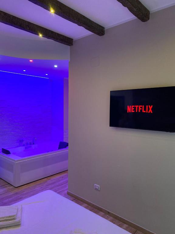 Hotel B&B New Paris & Suite, a television on a wall in a room with purple lights at B&B New Paris & Suite in Taranto