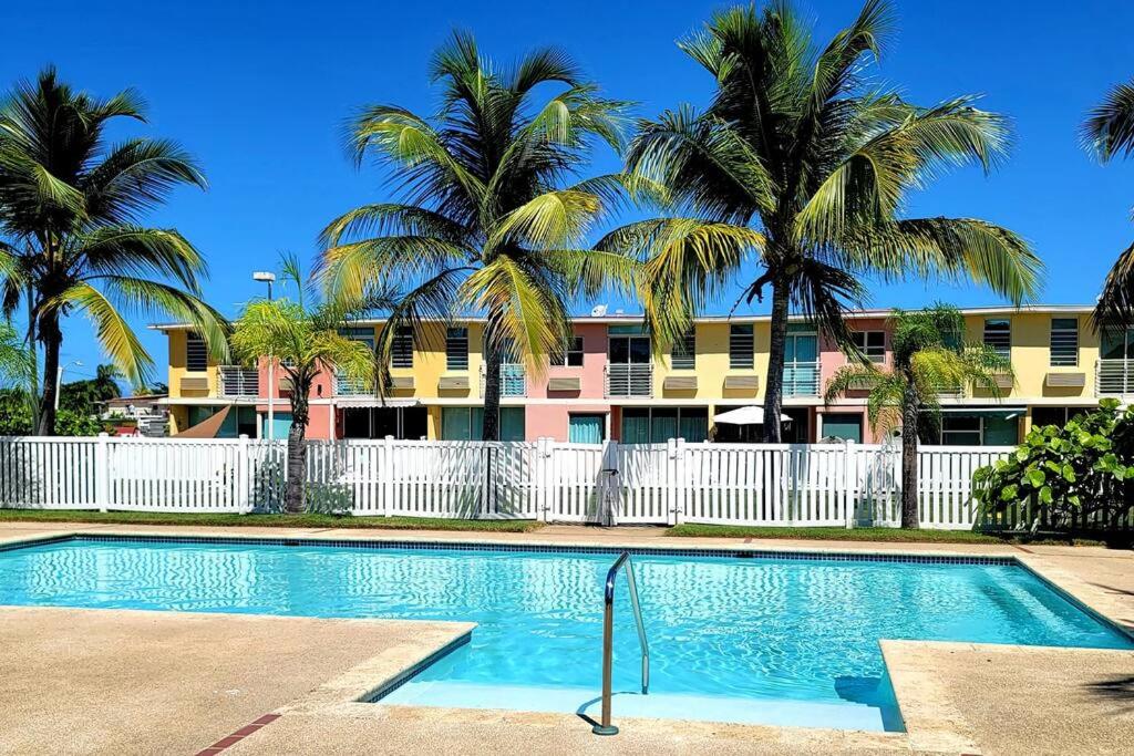 a swimming pool in front of a building with palm trees at Near Islaverde Beach home Carolina Puerto Rico. in Carolina