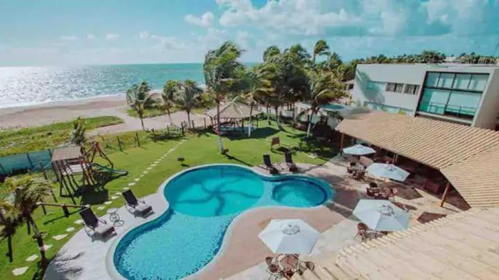 an aerial view of a resort with a swimming pool at Areias de Itacimirim 104 Village - Pé na Areia in Itacimirim