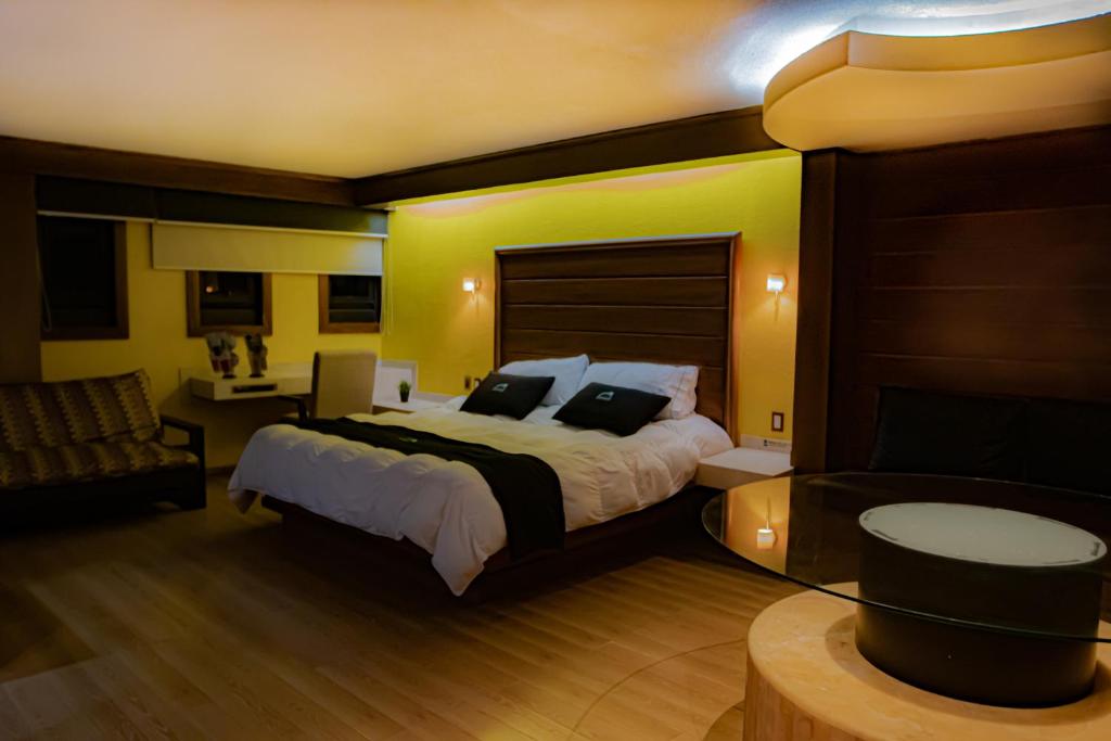 1 dormitorio con 1 cama grande y 1 sofá en Hotel Contadero Suites y Villas, en Ciudad de México