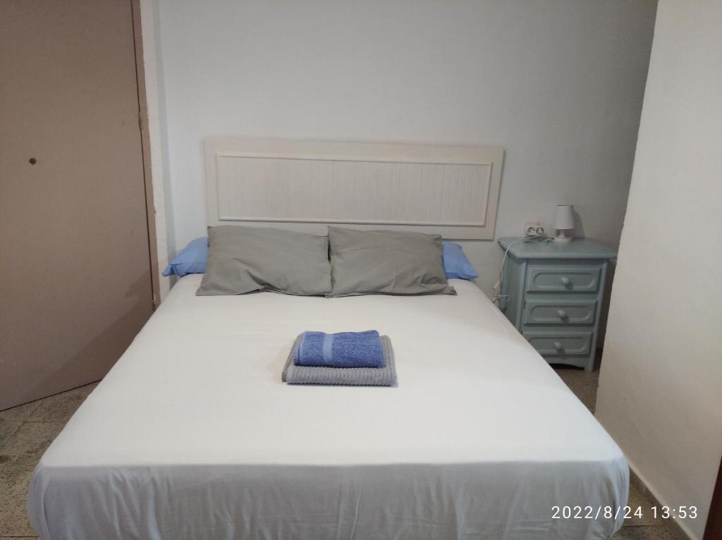 a large white bed with a blue towel on it at Vivienda Turística Templo Romano in Córdoba