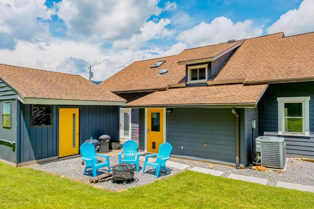 a yard with blue chairs and a house at Old Lytle Cove Rd - Lower Unit in Swannanoa
