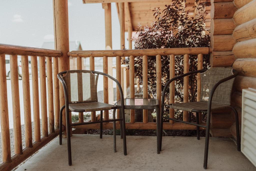 a pair of chairs sitting on a porch at Bryce Canyon Log Cabins in Tropic