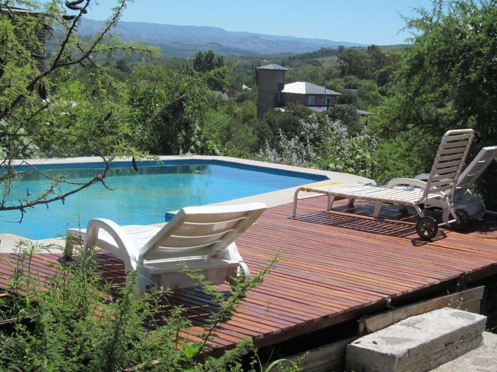 a deck with two chairs and a swimming pool at Alpa'y Kanki in Alpa Corral