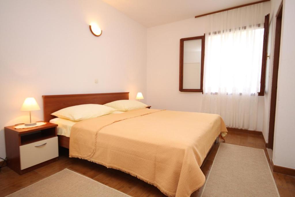 um quarto com uma cama grande e uma janela em Apartments with a parking space Baska Voda, Makarska - 2609 em Baska Voda