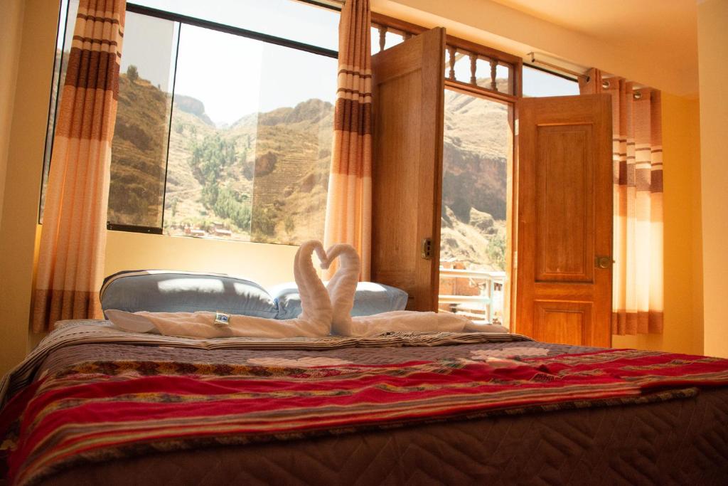 a bedroom with a bed with a large window at Hotel Everest in Pisac