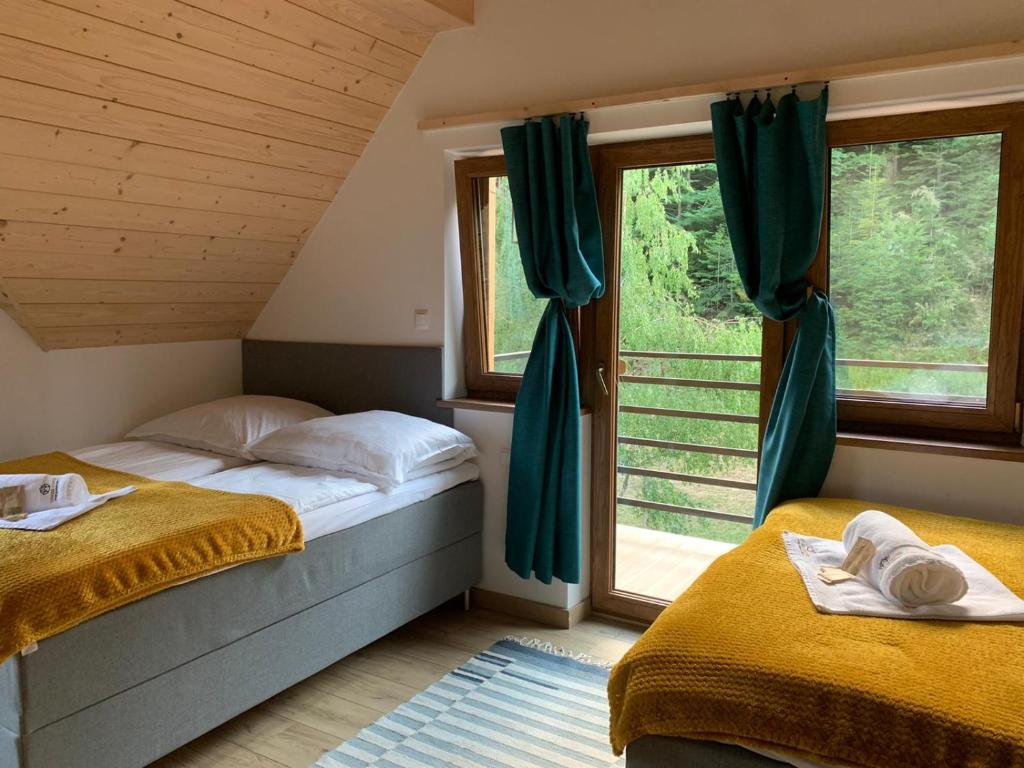 a bedroom with two beds and a window at Osada Gorce in Nowy Targ