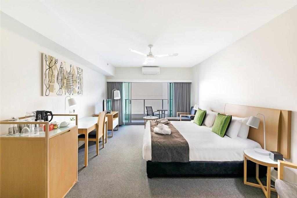 a hotel room with a large bed and a desk at King Balcony Suite at Resort Style Darwin Stay in Darwin