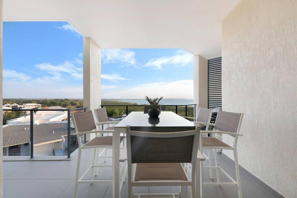 Nightcliff的住宿－Sleek Penthouse Style meets Stunning Coastal Views，美景阳台配有白色的桌椅