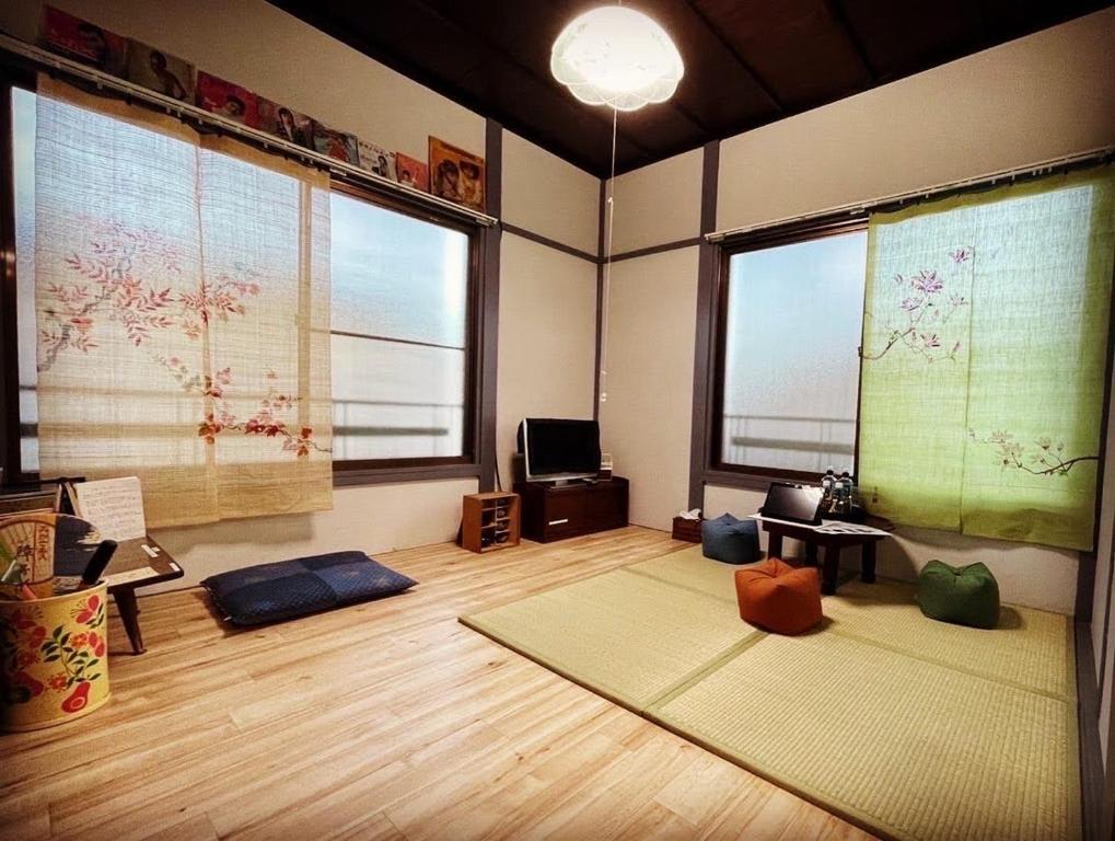 salon z dwoma dużymi oknami i matami w obiekcie 無料温泉チケット付 Oyado-Ichigo-Nie お宿一期二笑 #IG1 w mieście Ito