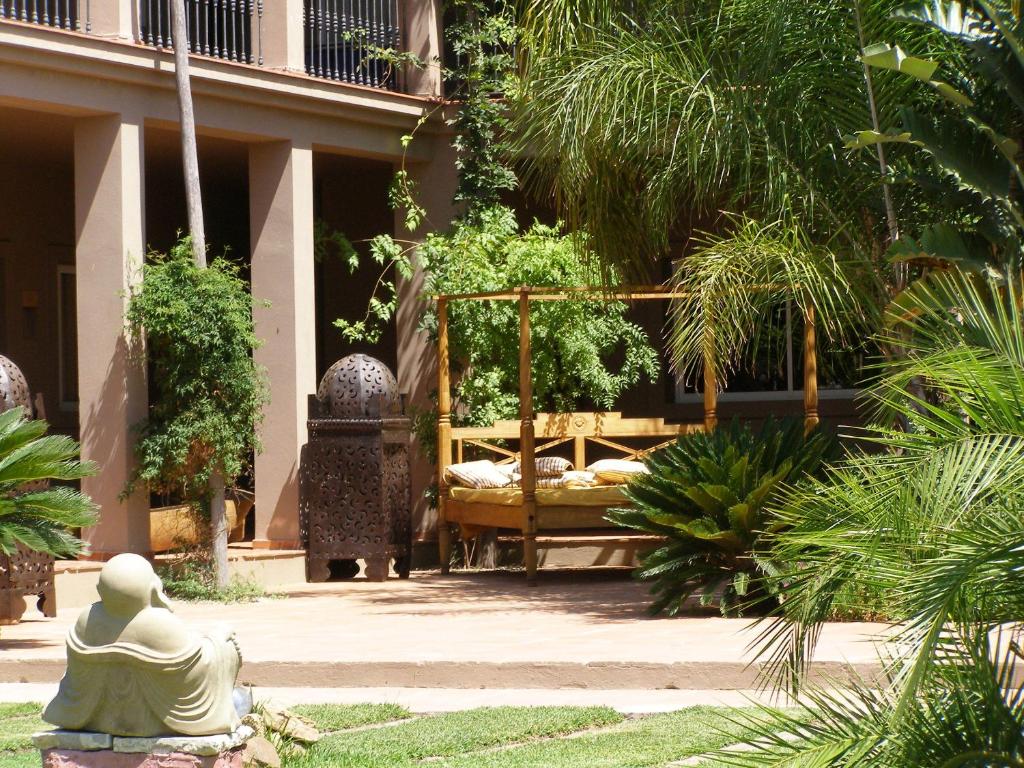 een tuin met een bed in het midden van een gebouw bij Chillout Hotel Tres Mares in Tarifa