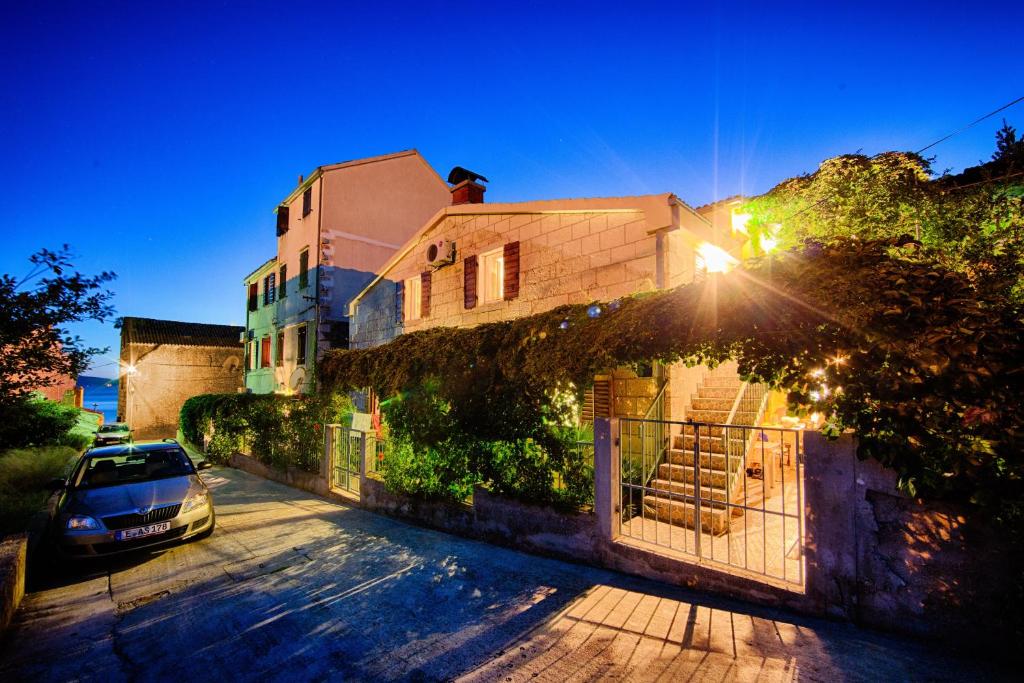 a building with a car parked in front of it at Apartments by the sea Komiza, Vis - 2450 in Komiža