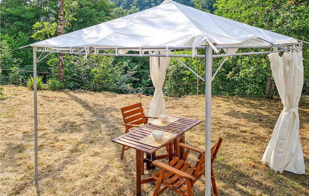 stół i krzesła pod białym baldachimem w obiekcie Nice Apartment In Santo Stefano Daveto w mieście Santo Stefano dʼAveto