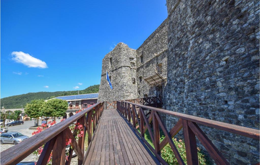 drewniana ścieżka obok dużego kamiennego budynku w obiekcie Nice Apartment In Santo Stefano Daveto w mieście Santo Stefano dʼAveto