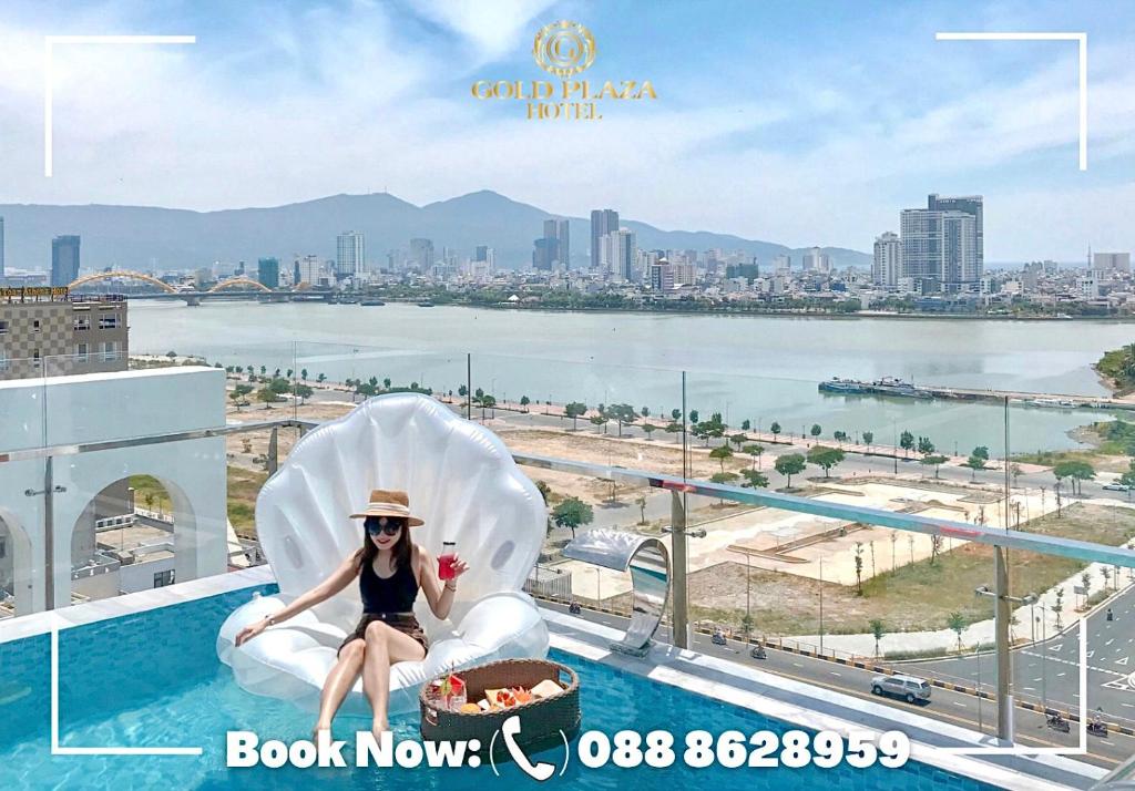 A rooftop pool scene with a guest seated on a white shell-shaped lounger above the waterfront.