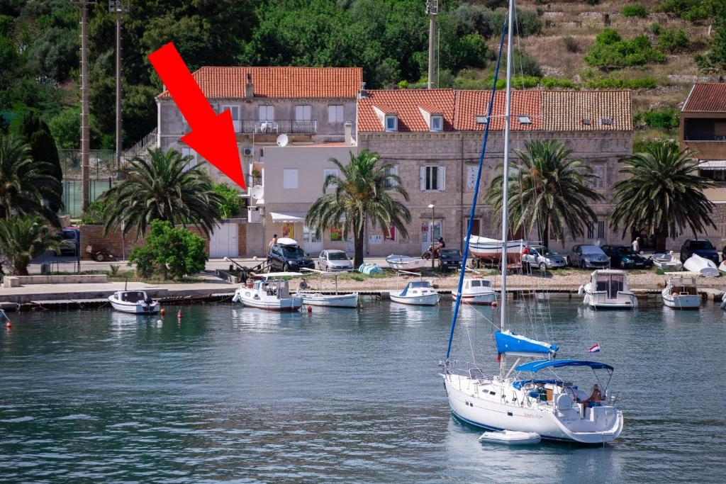 a sail boat in the water with a red flag at Apartments by the sea Vis - 2453 in Vis