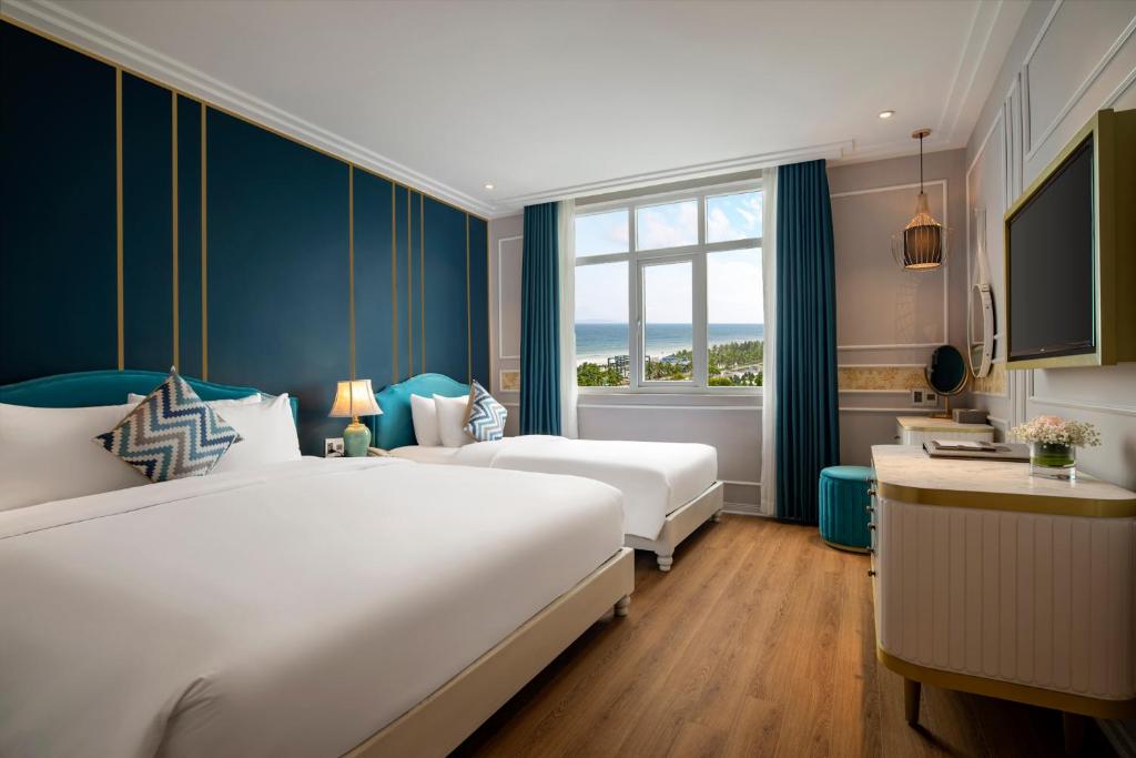 Cette chambre comprend 2 lits et une fenêtre. dans l'établissement Angel Hotels Beach Danang, à Đà Nẵng