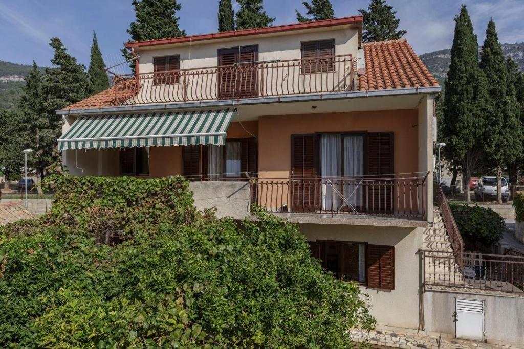 een appartementencomplex met een balkon en bomen bij Apartments with WiFi Komiza, Vis - 2420 in Komiža