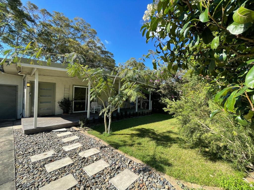 a backyard with a stone walkway in front of a house at Elizabeth Beach Guest House in Elizabeth Beach