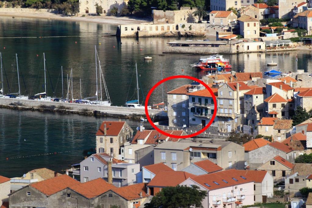 a red circle in a city with houses and boats at Apartments and rooms by the sea Komiza, Vis - 2431 in Komiža