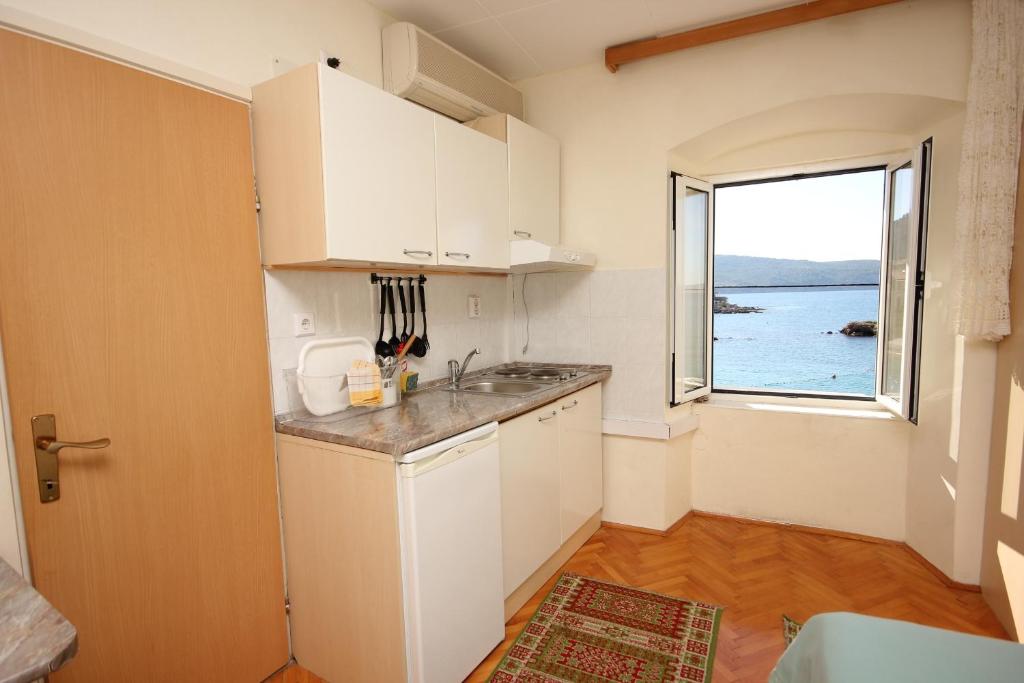 a kitchen with a sink and a window at Apartments and rooms by the sea Komiza, Vis - 2431 in Komiža