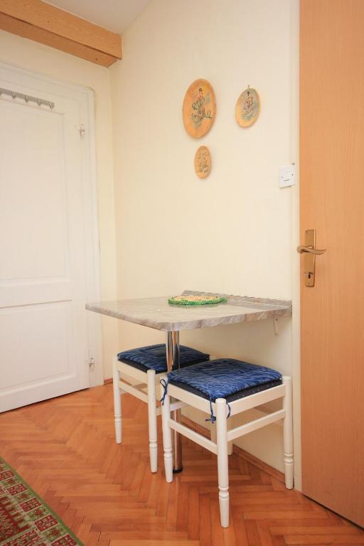 a table and two stools in a room at Apartments and rooms by the sea Komiza, Vis - 2431 in Komiža