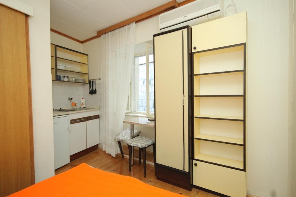 a kitchen with a refrigerator and a table at Apartments and rooms by the sea Komiza, Vis - 2431 in Komiža
