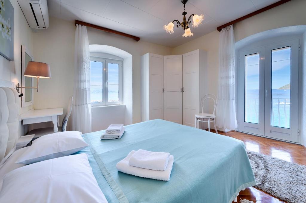 a bedroom with a blue bed with two towels on it at Apartments and rooms by the sea Komiza, Vis - 2431 in Komiža