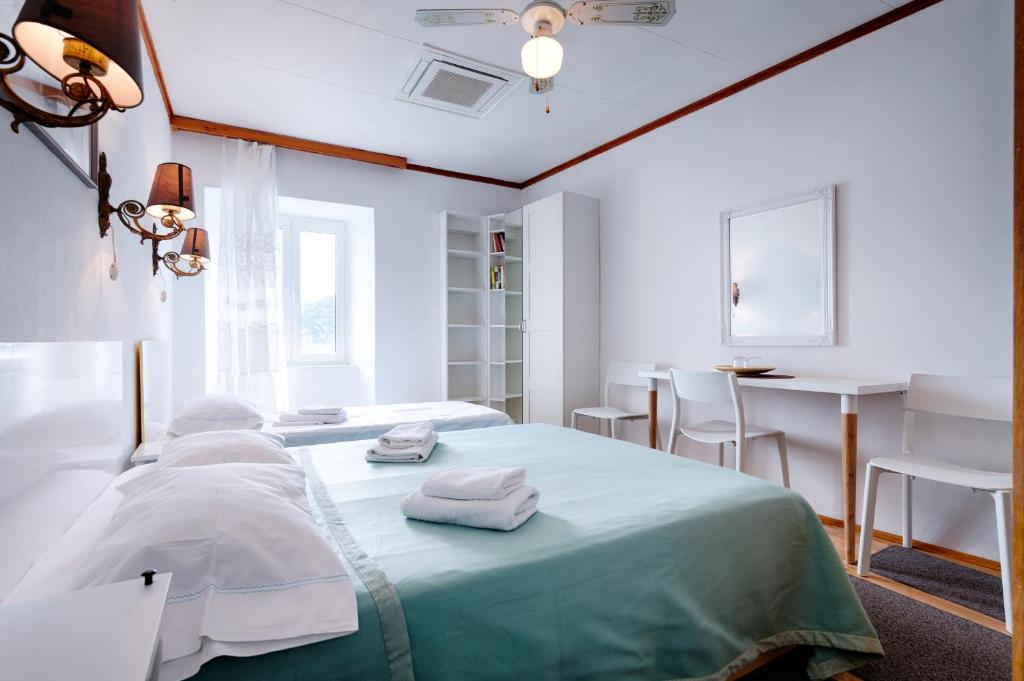 a white room with a bed with towels on it at Apartments and rooms by the sea Komiza, Vis - 2431 in Komiža
