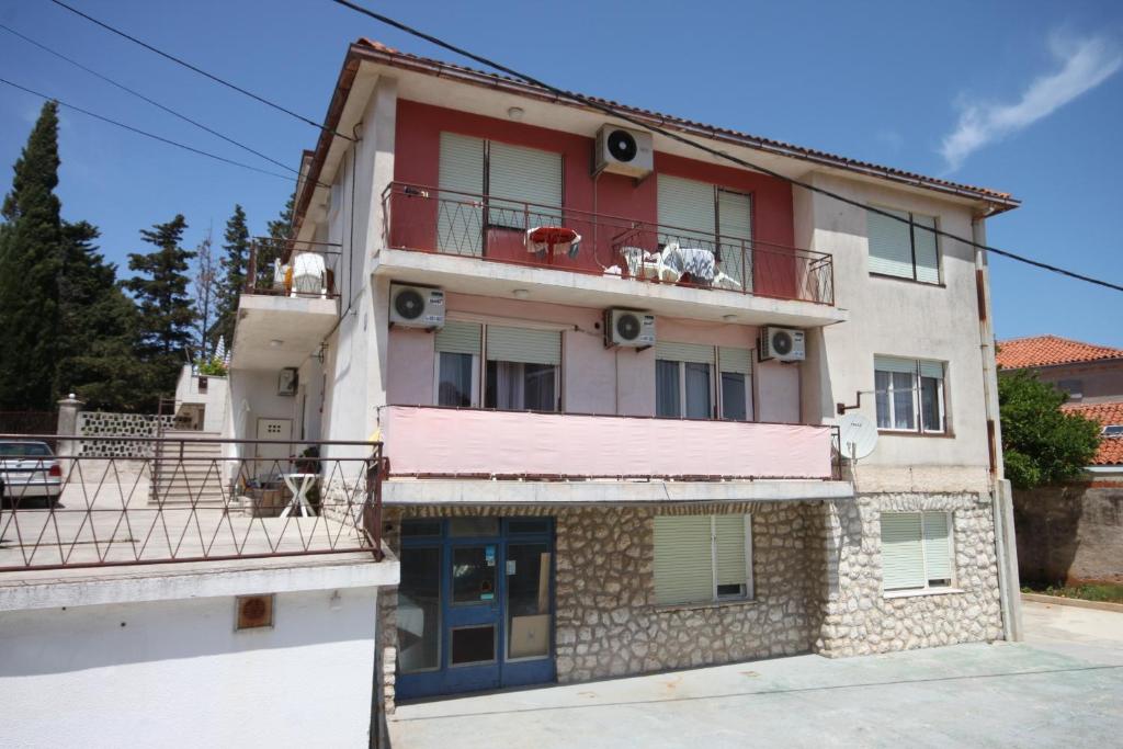 an apartment building with a dog on the balcony at Apartments and rooms with parking space Mali Losinj (Losinj) - 2486 in Mali Lošinj