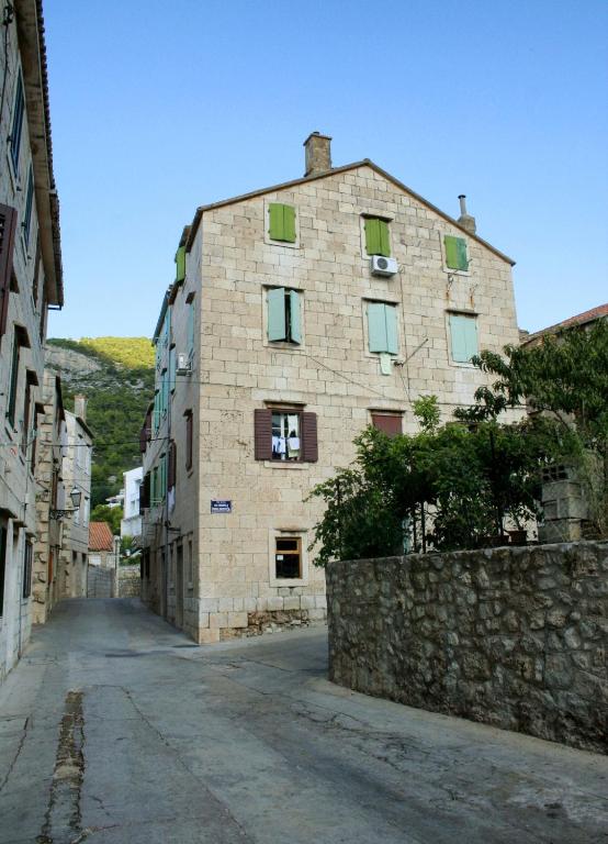 a large stone building on an empty street at Apartments by the sea Komiza, Vis - 2429 in Komiža