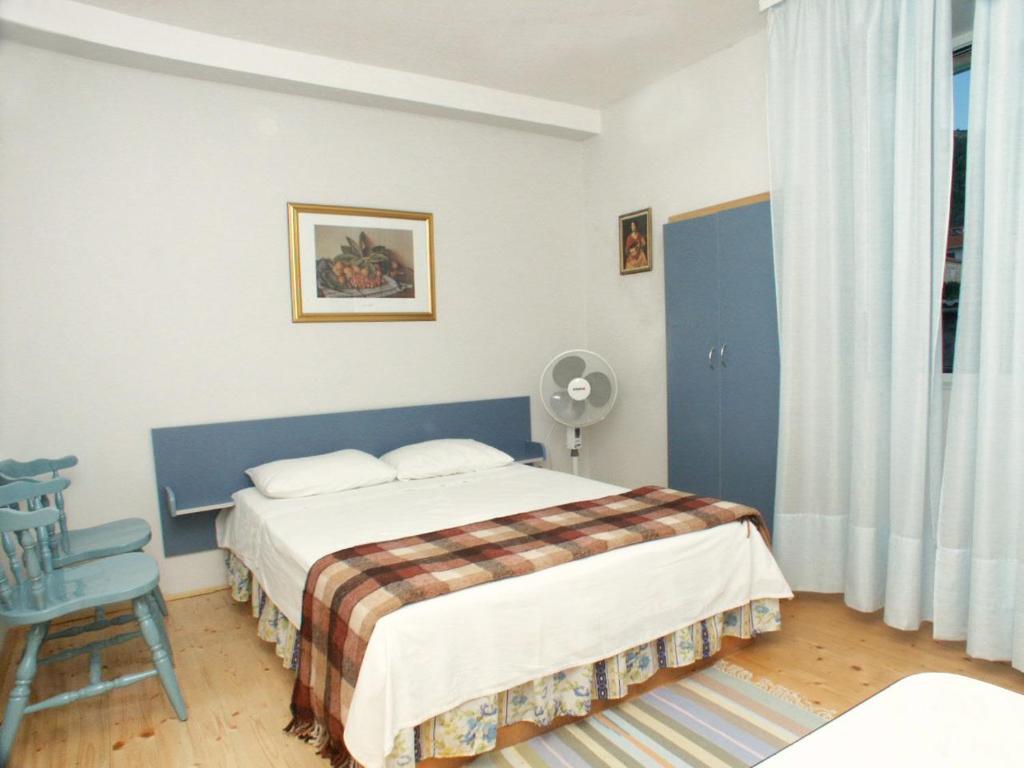 una camera con un letto e una sedia e una finestra di Apartments by the sea Komiza, Vis - 2429 a Komiža