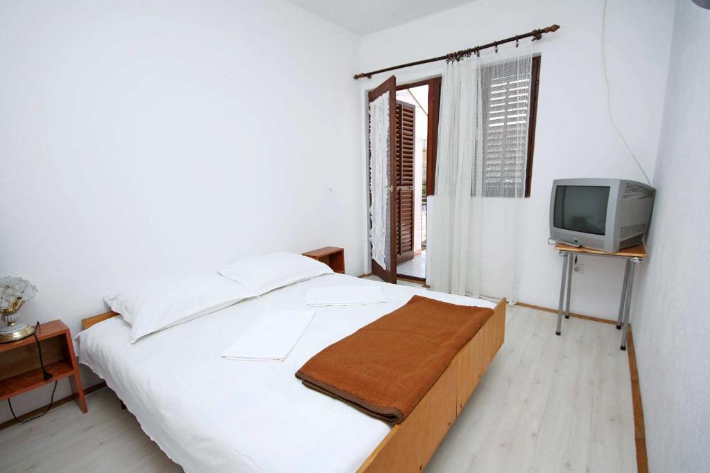 a white bedroom with a bed and a tv at Double Room Podaca 2613a in Podaca
