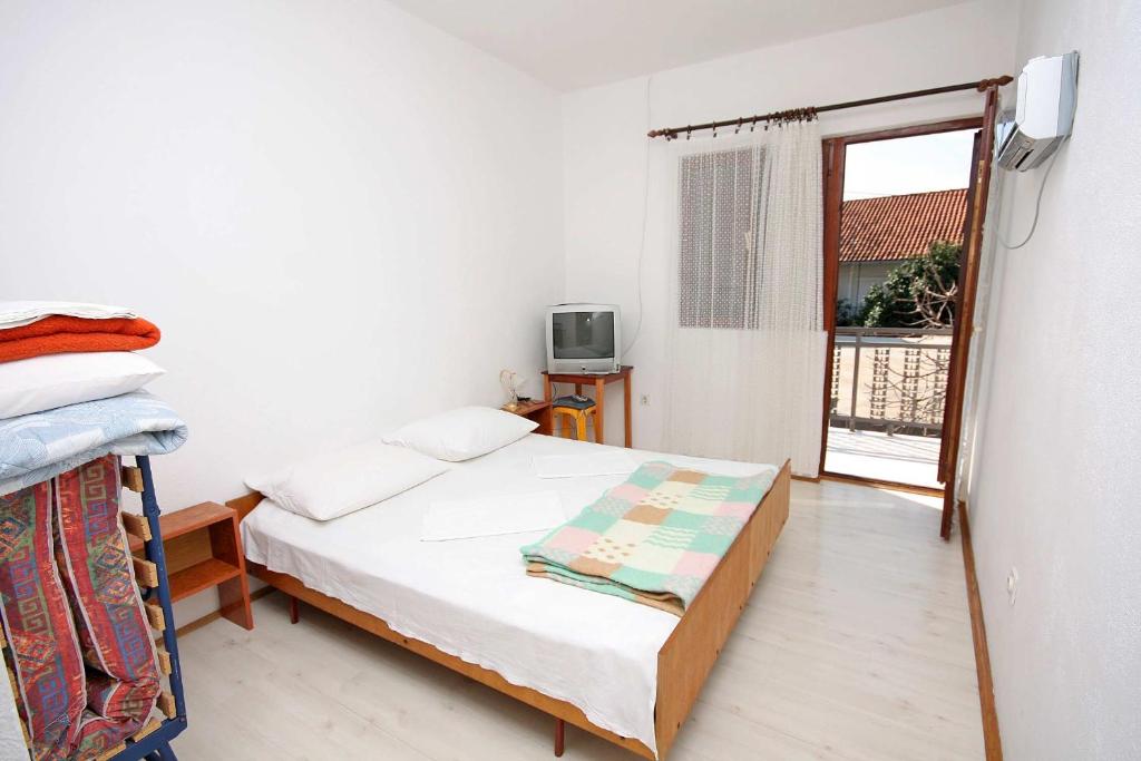 a small bedroom with a bed and a window at Double Room Podaca 2613b in Podaca