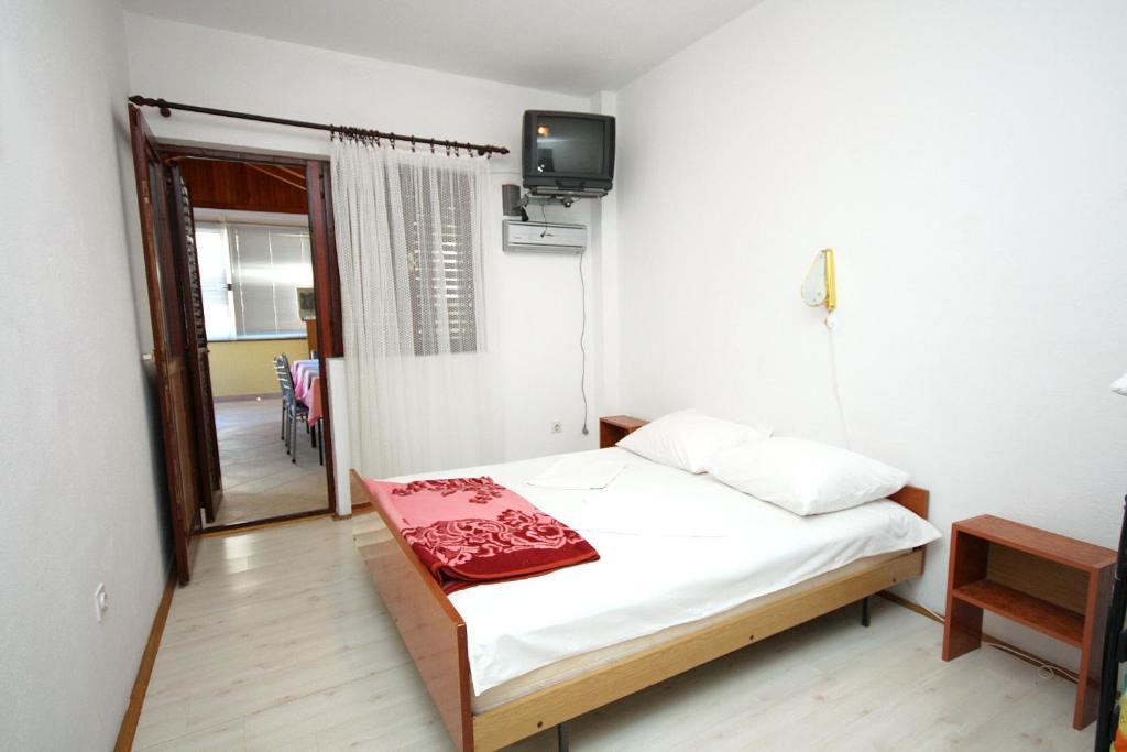 a bedroom with a bed and a tv on the wall at Double Room Podaca 2613c in Podaca