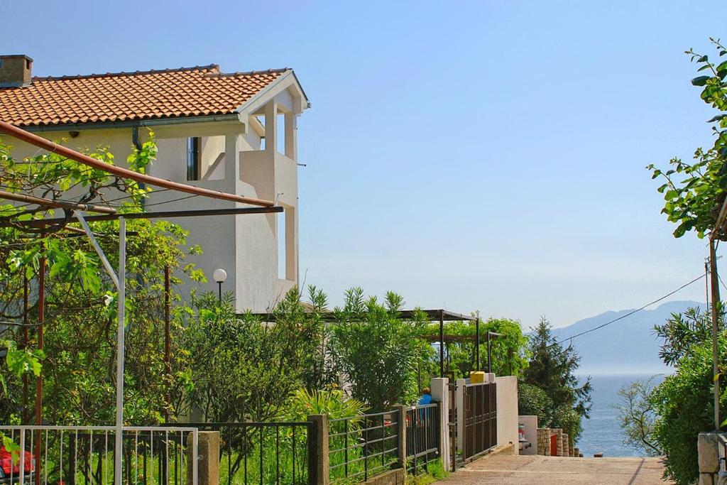 uma casa com uma cerca e vista para o oceano em Apartment Podaca 2621a em Podaca