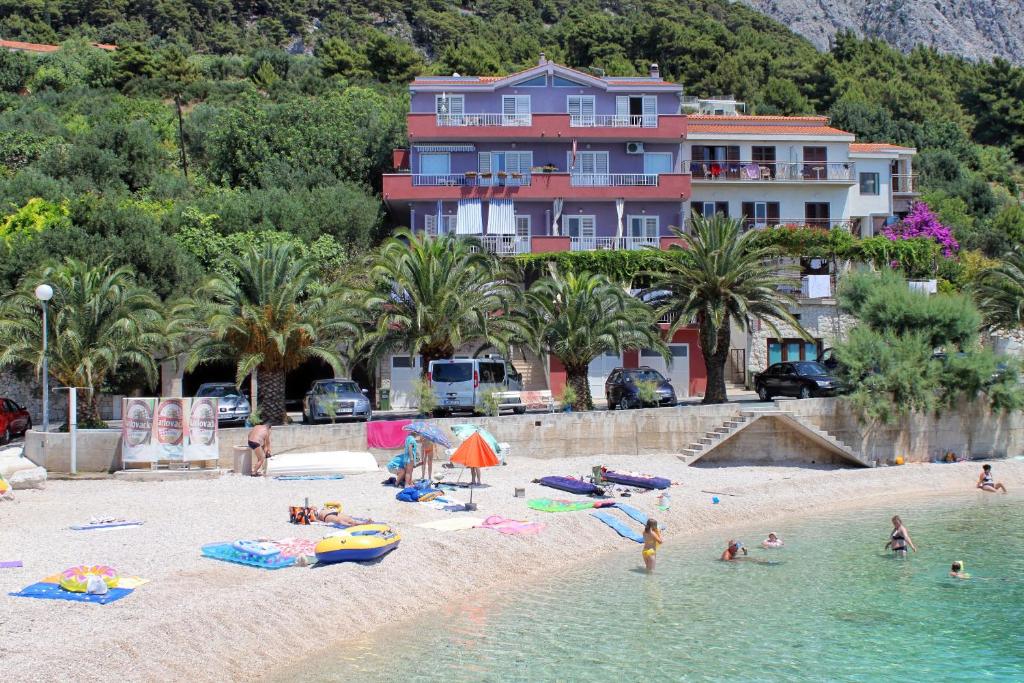 une plage avec un groupe de personnes dans l'eau dans l'établissement Apartments and rooms by the sea Podgora, Makarska - 2616, à Podgora