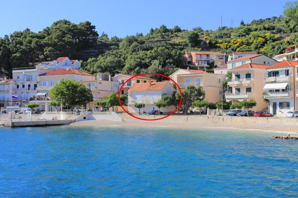 un cercle rouge sur une plage près de l'eau dans l'établissement Apartments by the sea Podgora, Makarska - 2657, à Podgora