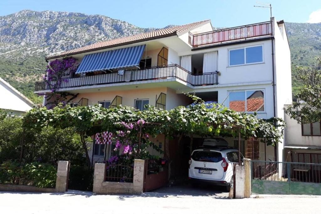 a white car parked in front of a house at Apartments by the sea Podaca, Makarska - 2612 in Podaca