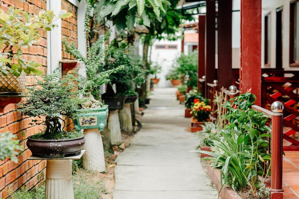 a garden path with potted plants on a building at Ngoc Qui Bungalow in Phú Quốc