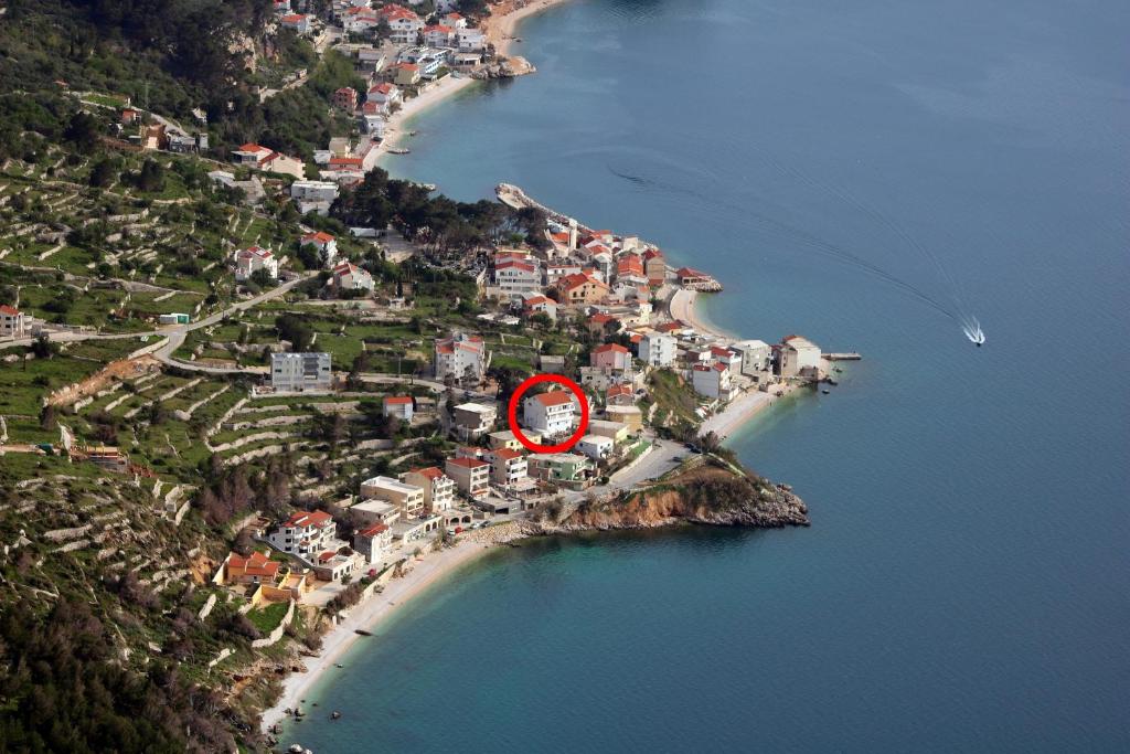 a red clock on a small island in the water at Apartments by the sea Drasnice, Makarska - 2581 in Drasnice