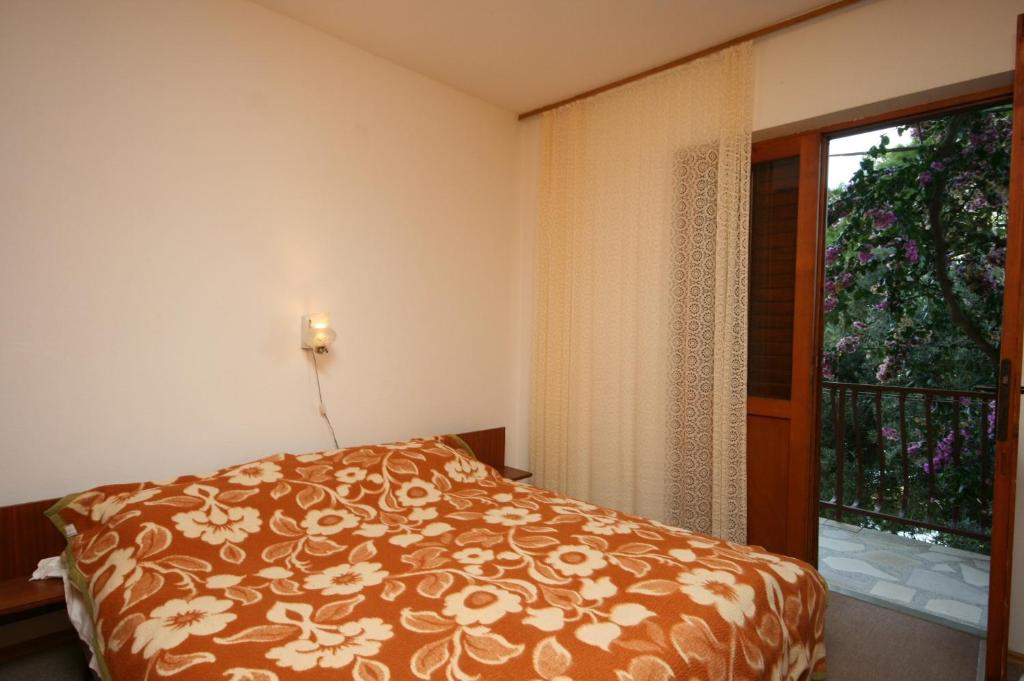 a bedroom with a bed and a window at Apartments by the sea Zivogosce - Mala Duba, Makarska - 2603 in Igrane