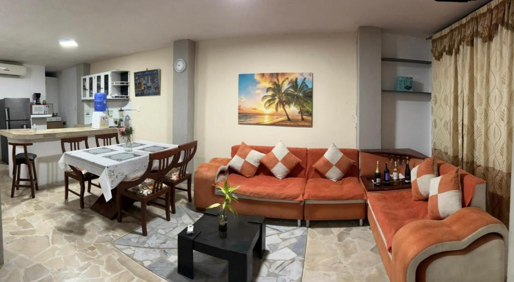 ein Wohnzimmer mit einem Sofa und einem Tisch in der Unterkunft Acogedor, amplio a 5 min de Las Palmas-Esmeraldas in Esmeraldas