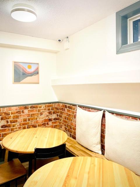 a dining room with two tables and a brick wall at Banff International Hostel in Banff