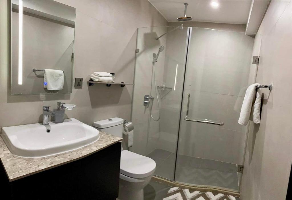 bagno con doccia, lavandino e servizi igienici di Aeon Towers Executive Suite 2BR 18th floor a Davao