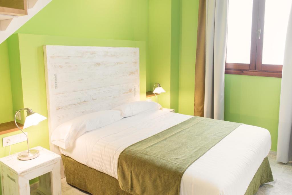 バレンシアにあるアド ホック カルメンの緑の壁のベッドルーム1室(大型ベッド1台付)