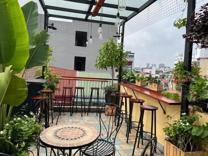 eine Terrasse mit Stühlen und Tischen auf dem Balkon in der Unterkunft Hanoi EcoStay 2 hostel in Hanoi