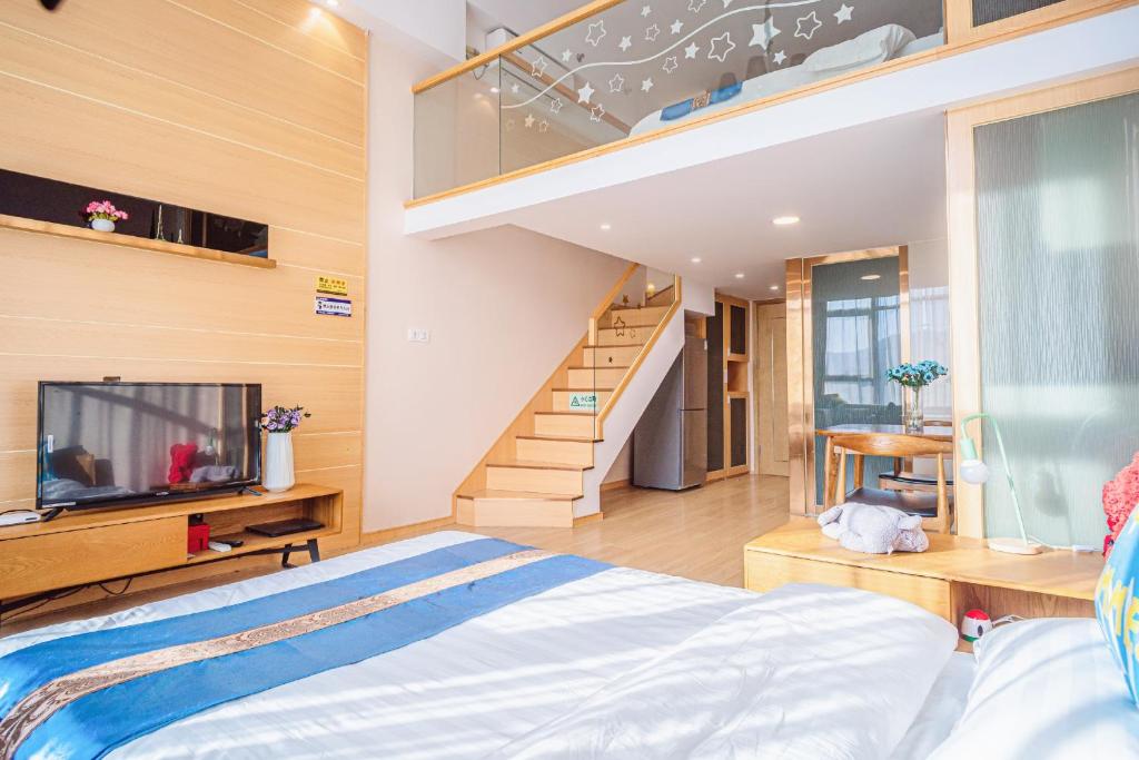 a bedroom with a bed and a tv and a staircase at July Apartment in Hangzhou